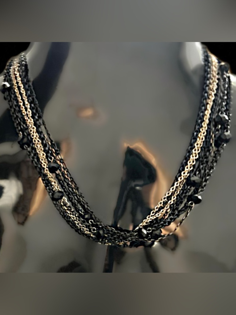 Multi-strand layered chain necklace accented with faceted black beads.